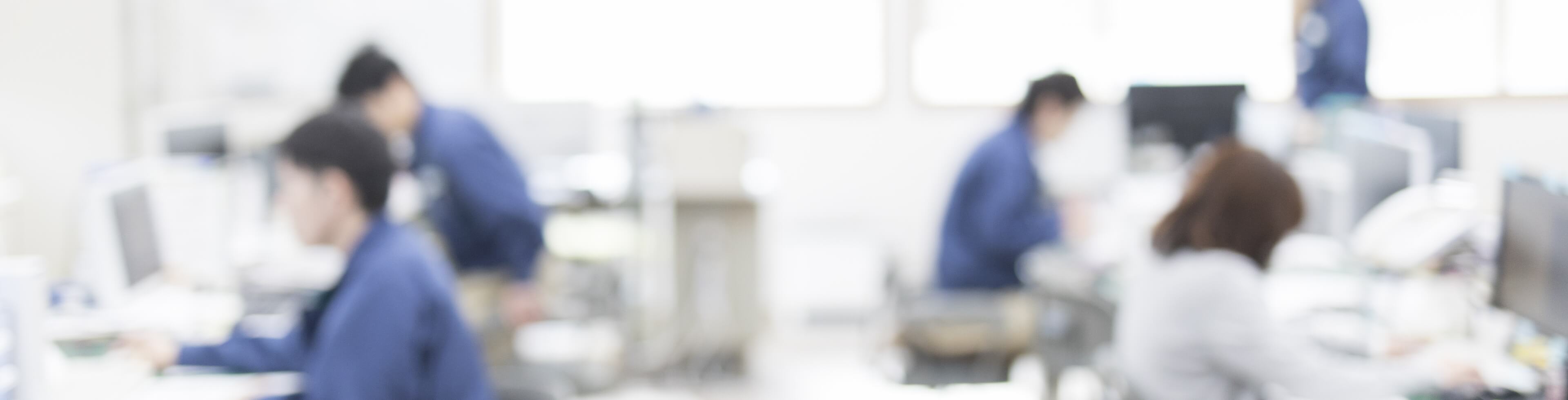 工場の前で話し合いをしている3人の社員