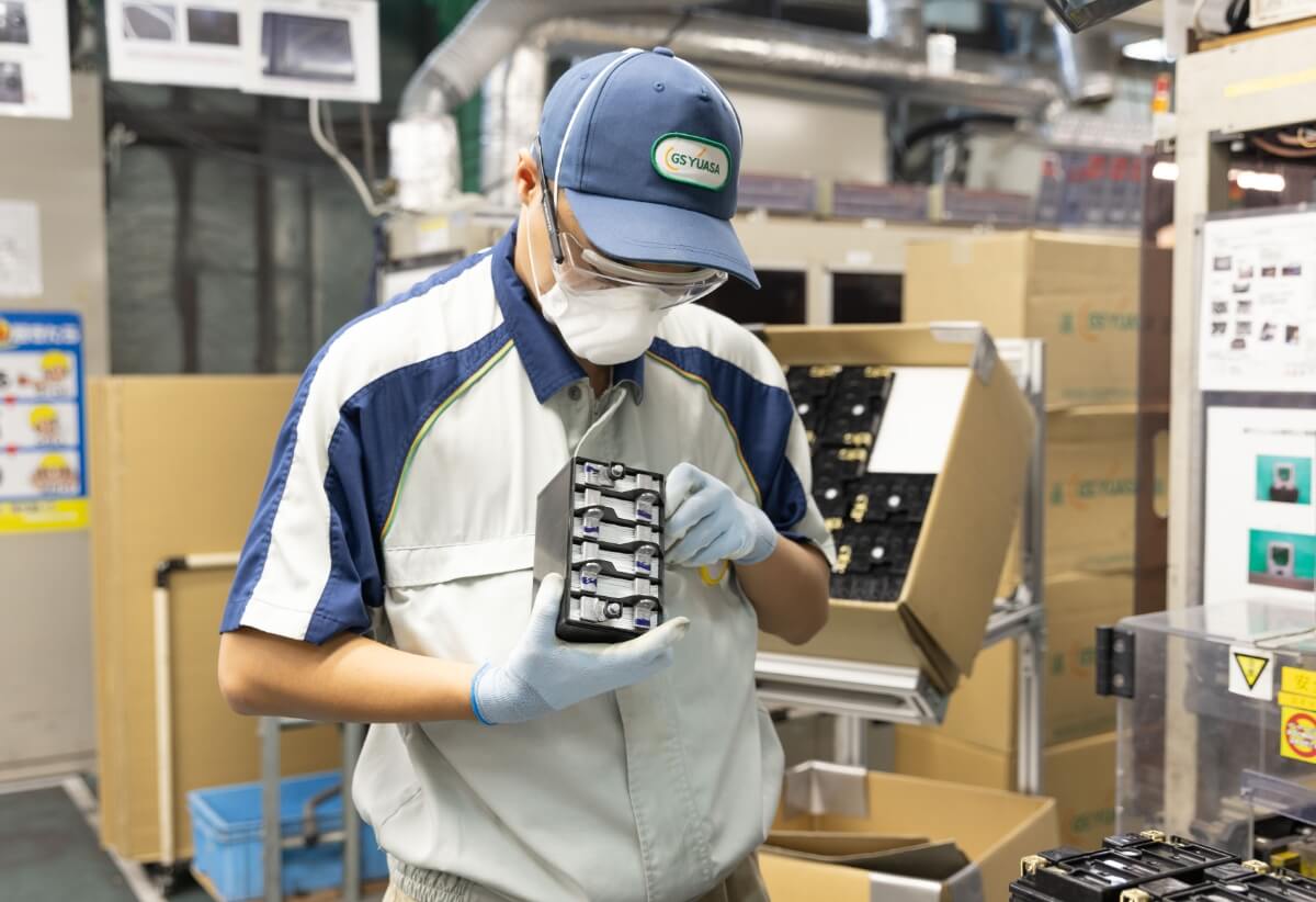 バイク用バッテリーの外観検査を行う作業員の様子